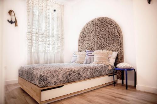 Schlafzimmer mit einem Bett mit verziertem Kopfteil in der Unterkunft Jazmin 6 ( whole apartment ) in Alicante