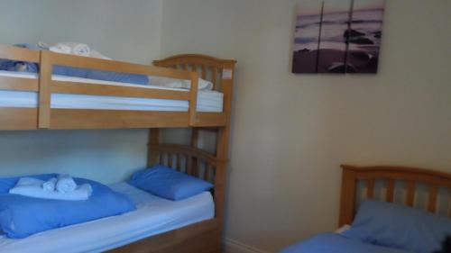 two bunk beds with blue pillows in a room at Woolacombe Seaside Apartment in Woolacombe