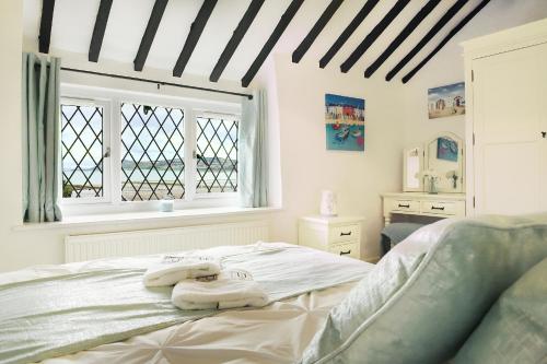a bedroom with a bed with two towels on it at Beautiful Beach Front Cottage in Llandudno