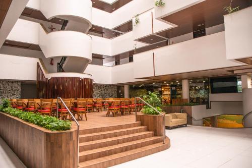 a lobby with a restaurant with tables and chairs at Matsubara Acqua Park Hotel in Maceió