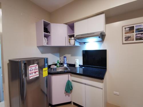 a small kitchen with a refrigerator and a sink at Avida Davao by davaobnb & Lemonique Homes in Davao City