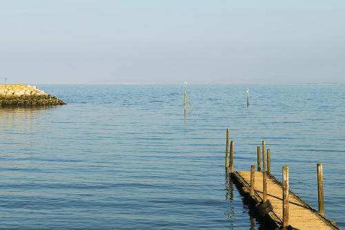 a dock in the middle of a large body of water at Beautiful Beach Front Cottage in Llandudno