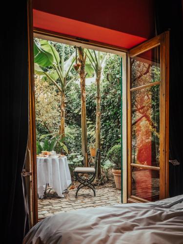 a bedroom with a door open to a patio with a table at Jardins Secrets in Nîmes