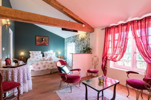 - une chambre avec un lit, une table et des chaises dans l'établissement Les Nuits du Pastelier, à Teulat