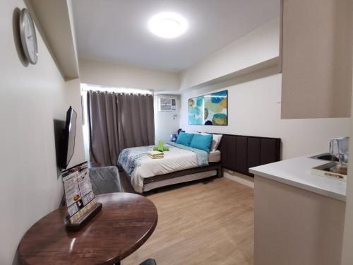 a small living room with a bed and a table at Avida Davao by davaobnb & Lemonique Homes in Davao City