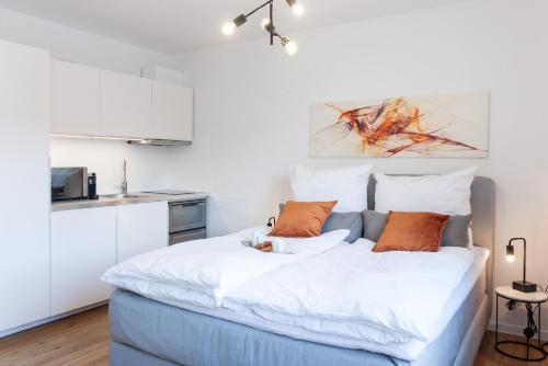 una camera da letto con un letto con cuscini bianchi e arancioni di Modernes Apartment Liobablick Nr1 FeWo Fulda Petersberg a Petersberg