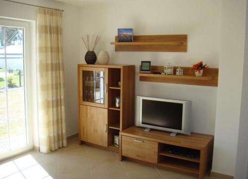 a living room with a television on a wooden entertainment center at Ferienhaus „Sonneninsel“ in Ostseebad Karlshagen