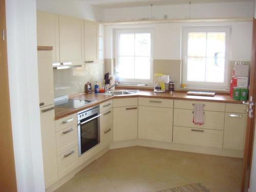 a kitchen with white cabinets and a stove top oven at Ferienhaus „Sonneninsel“ in Ostseebad Karlshagen