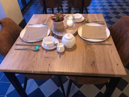 a wooden table with plates and candles on it at B&B Langeveldemolen in Merchtem