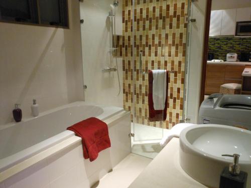 a bathroom with a white tub and a sink at Top Floor, One-Bedroom Apartment in Phuket Town