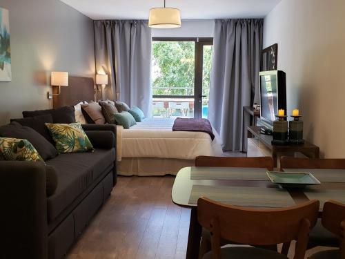 - un salon avec un canapé et un lit dans l'établissement URBANA SUITES & STUDIOS 440, à San Carlos de Bariloche