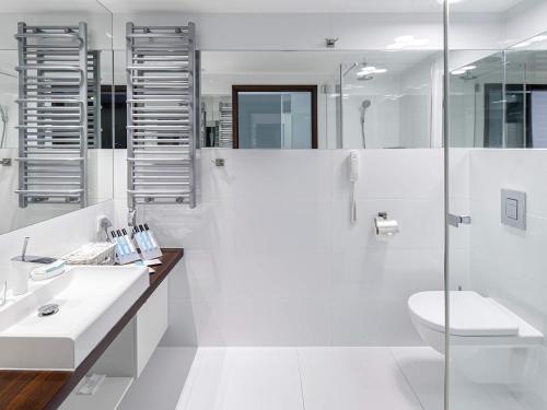 Baño blanco con lavabo y aseo en VacationClub – Marine Hotel Apartament 621 en Kołobrzeg