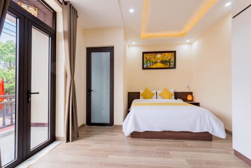 a bedroom with a bed and a large window at Green Hill Hotel in Hoi An
