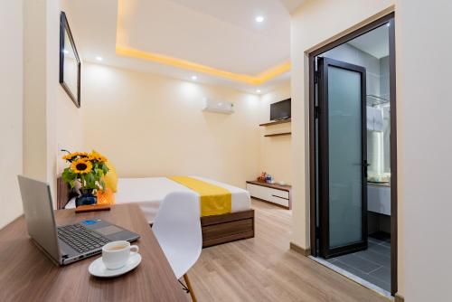 a small room with a desk with a laptop on it at Green Hill Hotel in Hoi An