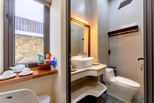 a bathroom with a sink and a toilet and a window at Green Hill Hotel in Hoi An