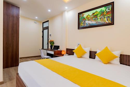 a hotel room with a large bed and a desk at Green Hill Hotel in Hoi An
