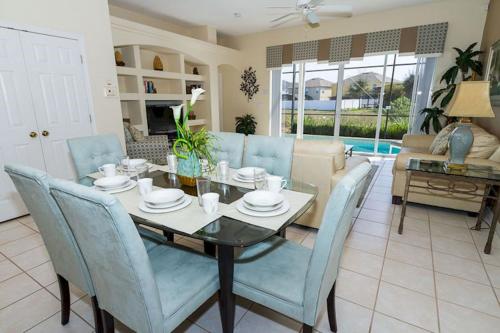 a dining room with a table and blue chairs at A wonderful choice for a family Vacation, 4 bedrooms and it own pool in Orlando