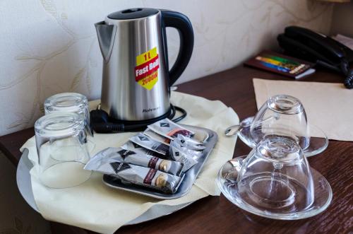 a coffee pot and glasses on a wooden table at Hotel Rokoko in Košice