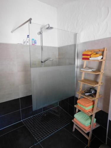 a bathroom with a shower and a shelf with towels at BellaVista in Baressa