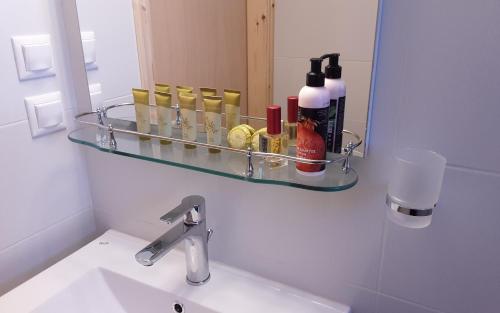 a bathroom mirror with a shelf above a sink at Nea Styra seafront apartment with stunning view in Nea Stira
