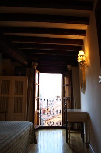 a bedroom with a bed and a door to a balcony at Hostería La Antigua in Potes