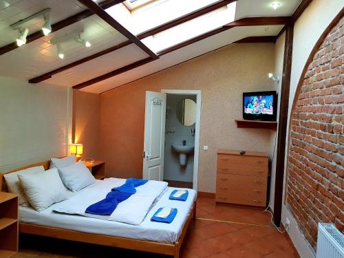 um quarto com uma cama grande e toalhas azuis em Hotel Sun em Lviv