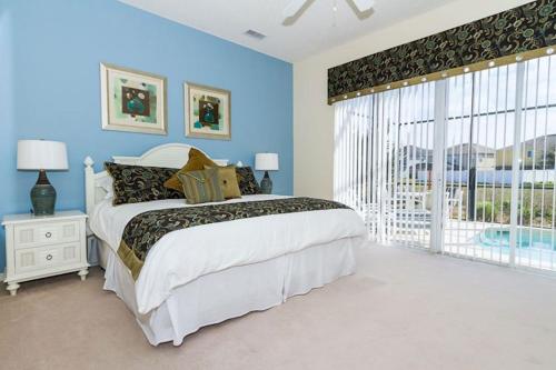 a bedroom with a large bed and a large window at A wonderful choice for a family Vacation, 4 bedrooms and it own pool in Orlando