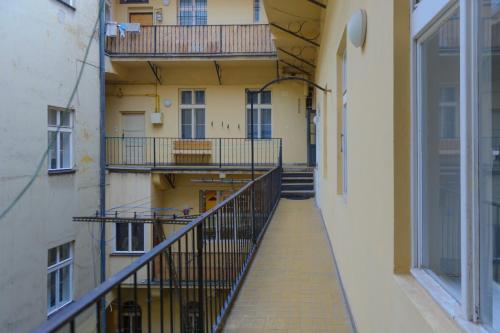 プラハにあるPinkova Apartmentsのバルコニー付きのアパートメントビルの空の廊下