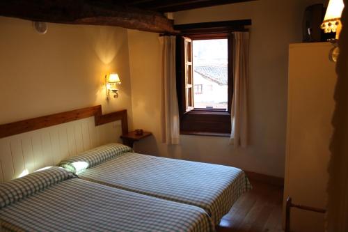 a bedroom with two beds and a window at Hostería La Antigua in Potes