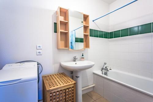 une petite salle de bain avec un lavabo et une baignoire dans l'établissement Sanguinet bel appartement 4 à 6 couchages plein centre ville proche commerces et lac, à Sanguinet