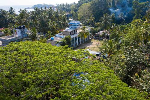 an aerial view of a house surrounded by trees at Zimmer Rest in Unawatuna