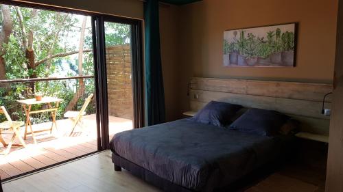 sypialnia z łóżkiem i przesuwnymi szklanymi drzwiami w obiekcie Le lodge origin w mieście Sainte-Suzanne