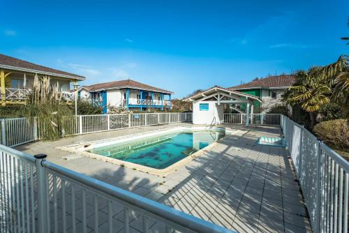 une maison avec piscine sur une clôture dans l'établissement Sanguinet bel appartement 4 à 6 couchages plein centre ville proche commerces et lac, à Sanguinet