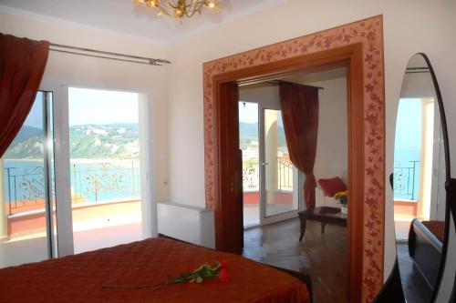 a bedroom with a bed and a view of the ocean at Romanza Villa in Agios Stefanos