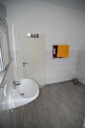 uma casa de banho com um lavatório branco e um espelho. em City Apartment Vohwinkel em Gelsenkirchen