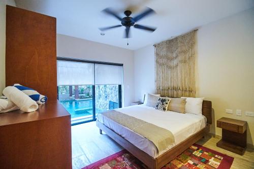 1 dormitorio con 1 cama y ventilador de techo en Beautiful Luxury Poolside Retreat in Aldea Zama Tulum en Tulum