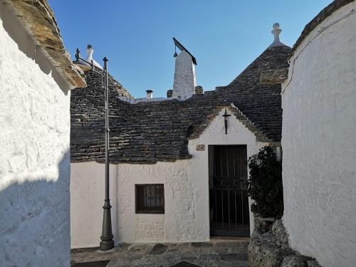 un edificio bianco con tetto nero di Trullo Nobilis ad Alberobello