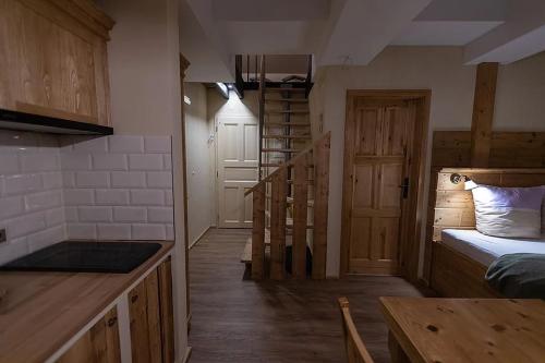 a room with a kitchen with a bed and a staircase at Stará škola in Dolní Malá Úpa