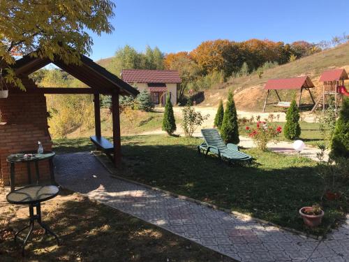 a park bench in a yard with a house at Cabana 7 Brazi in Poiana Mărului