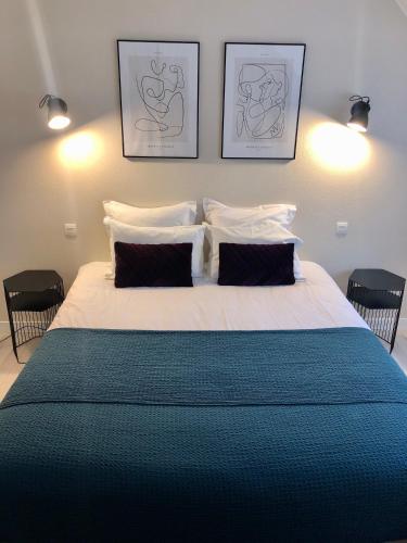 une chambre avec un grand lit avec deux oreillers dans l'établissement La Gervaiserie - 300m de la plage, à Réville