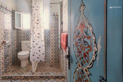 a bathroom with a toilet and a shower curtain at Casa Plasa Grande in Chefchaouen