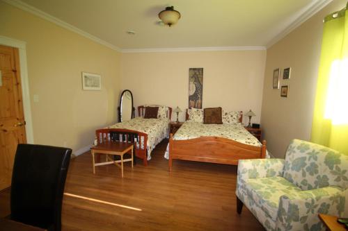 uma sala de estar com duas camas e um sofá em The Fiddle and the Sea Bed and Breakfast em Port Hood
