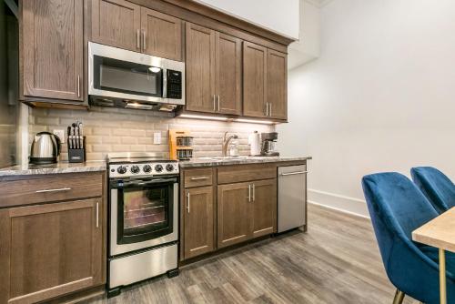 a kitchen with wooden cabinets and a microwave at 1 and 2 BR Private Condos Steps Away From French Quarter in New Orleans