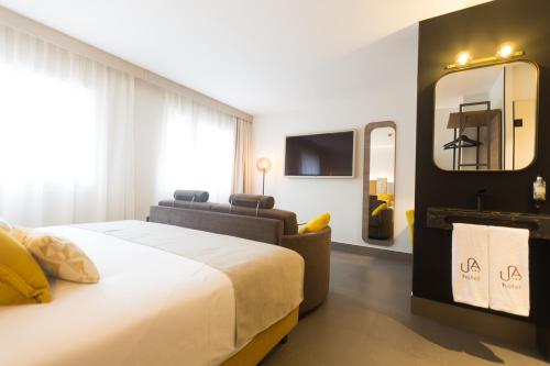 a bedroom with a large bed and a mirror at Urban A+++ Hotel in Tres Cantos