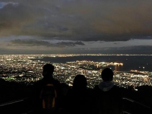 a group of people standing on top of a hill looking at a city at Kobe Guesthouse MAYA in Kobe