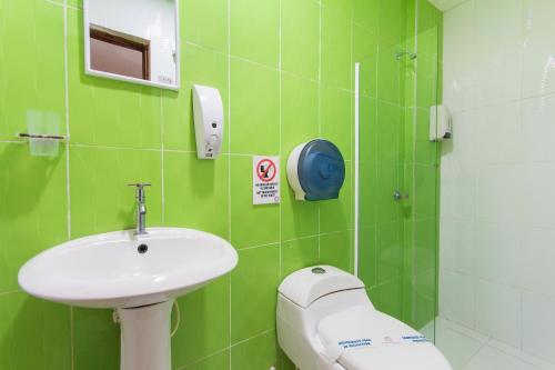 a bathroom with a toilet, sink, and mirror at Azuán Suites Hotel By GH Suites in Cartagena de Indias