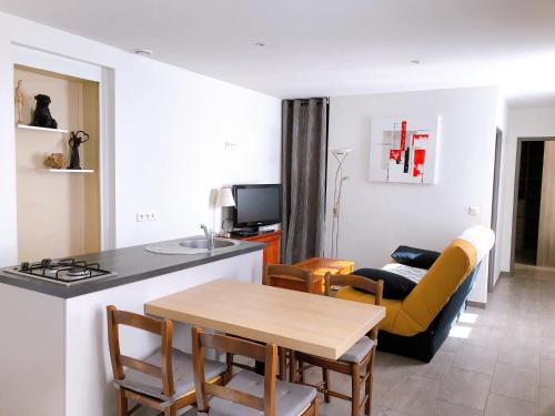 a kitchen and living room with a table and a couch at Le Rieussec in Saillans