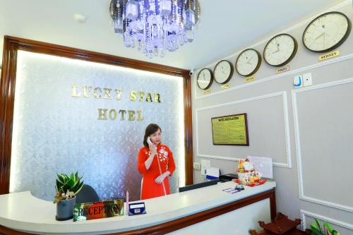 a man standing in front of a counter with a clock at Lucky Star Hotel 266 De Tham in Ho Chi Minh City