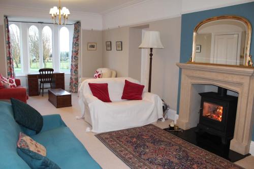 a living room with a white chair and a fireplace at High Rigg B&B in Helmsley