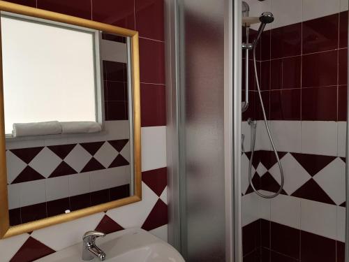 a bathroom with a sink and a shower with a mirror at Hotel Ristorante Radar in Carrara